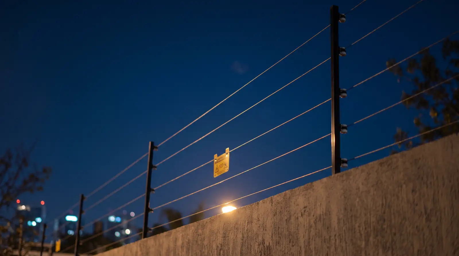 Cerco eléctrico sobre una barda residencial de noche