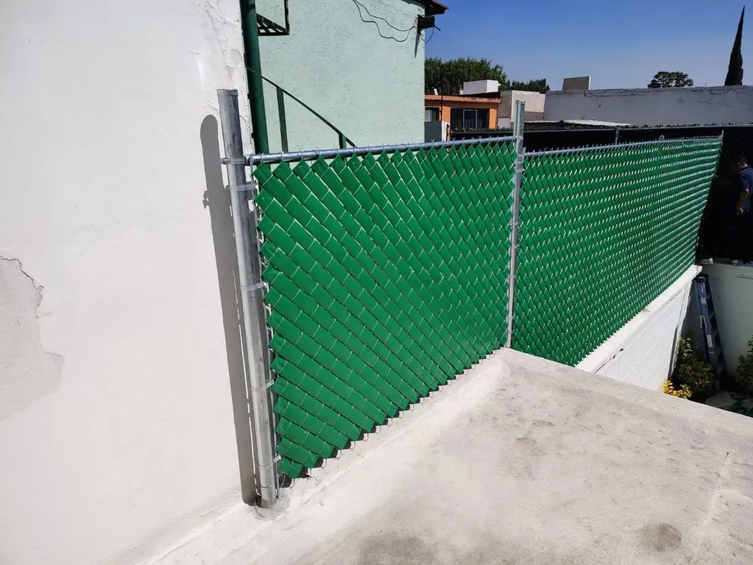 Malla con cinta de privacidad verde en una azotea