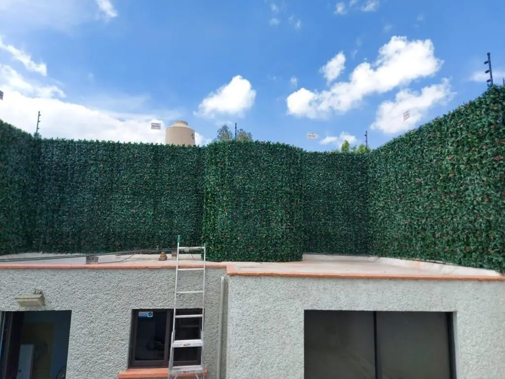 Azotea cerrada con paneles de follaje artificial